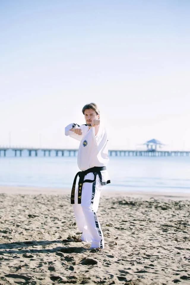 Strong Taekwon-Do students smiling together after training